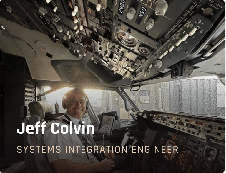Jeff Colvin, systems integration engineer, sits in an airplane cockpit with flight controls and avionics.